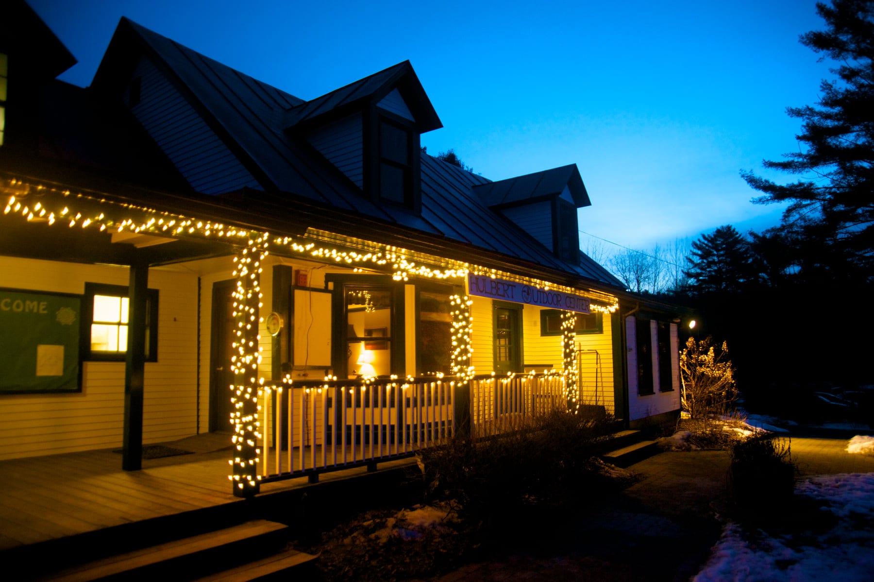 Welcoming lights in the evening on the front porch of Hulbert Outdoor Center's main lodge.