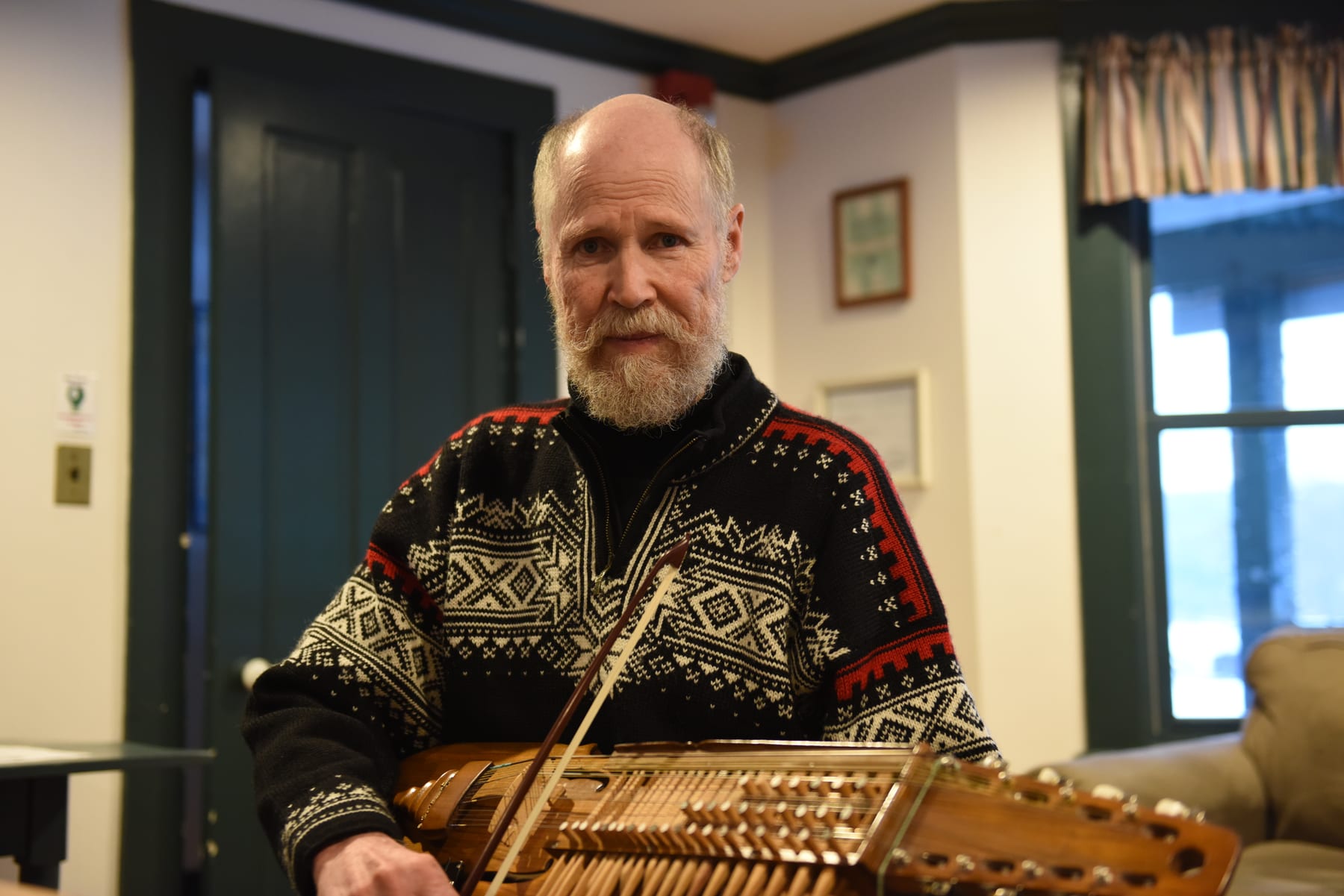 Stefan Ohlstrõm playing nyckelharpa during an informal session in the library at the Hulbert Outdoor Center.