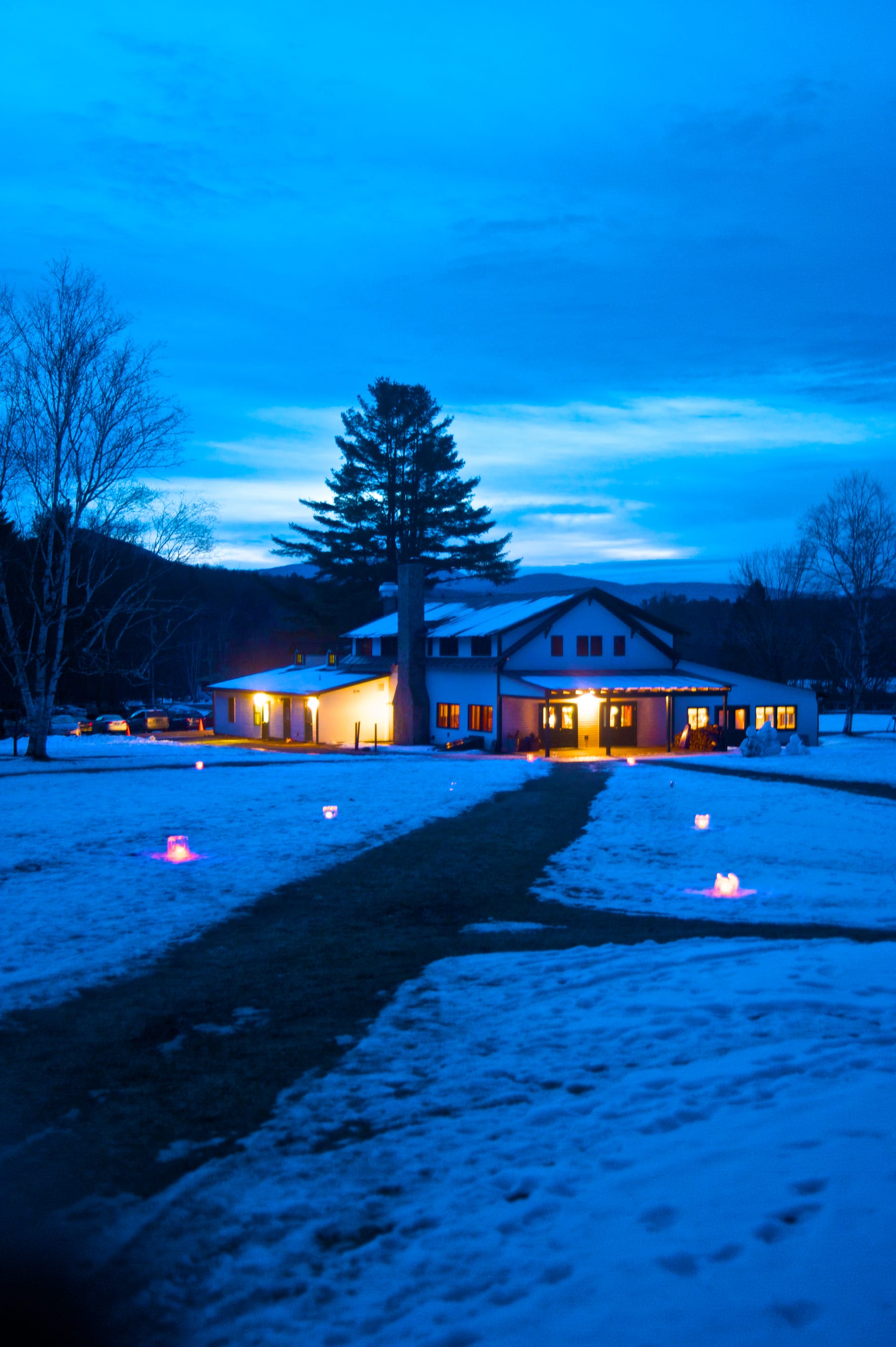 Snow candles illuminating and creating an enchanting path, welcoming participants from their cabins to the main lodge.